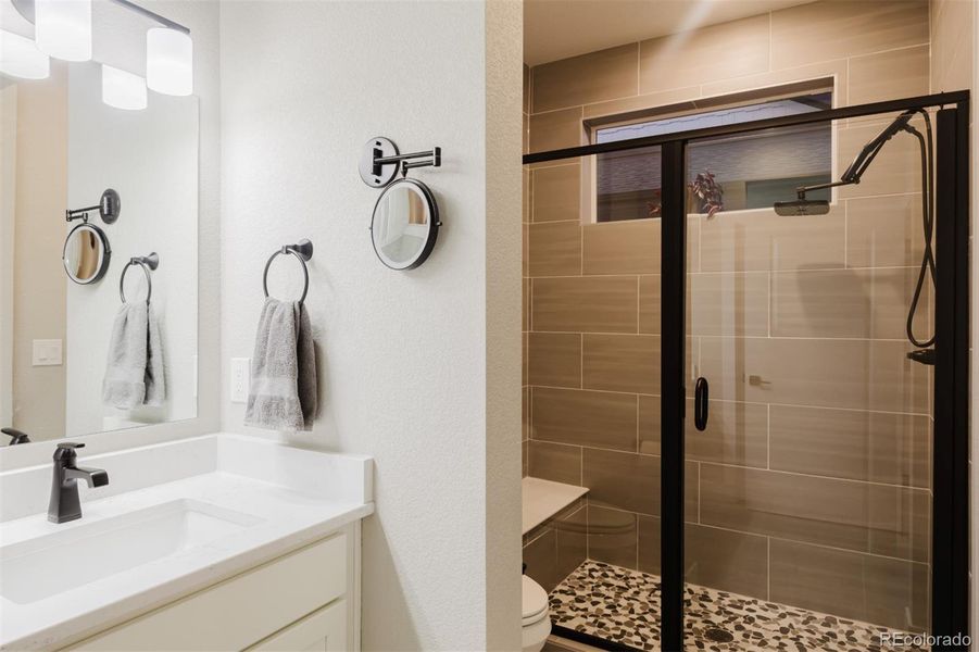 The oversized shower in the primary bath has a rainhead shower and a built-in seat. The oversized shower in the primary bath has a rainhead shower and a built-in seat.