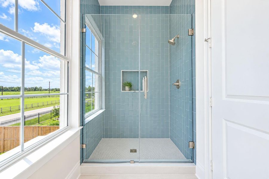 Sleek glass-enclosed shower in the secondary bath features contemporary tilework, modern fixtures, and a built-in niche for everyday essentials. A large window brings in natural light, adding a bright, fresh feel to this beautifully finished space. Sleek glass-enclosed shower in the secondary bath features contemporary tilework, modern fixtures, and a built-in niche for everyday essentials. A large window brings in natural light, adding a bright, fresh feel to this beautifully finished space.
