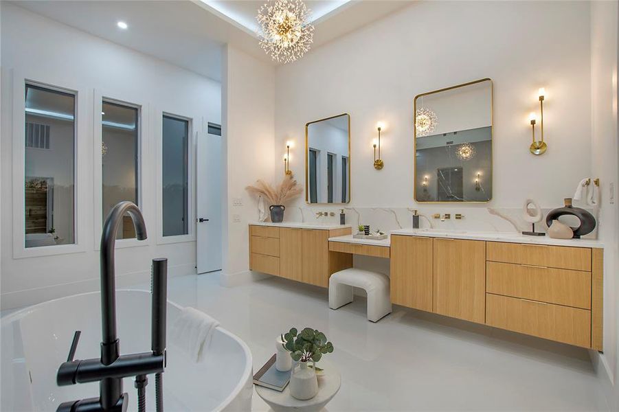 Bathroom featuring a chandelier, vanity, and a washtub