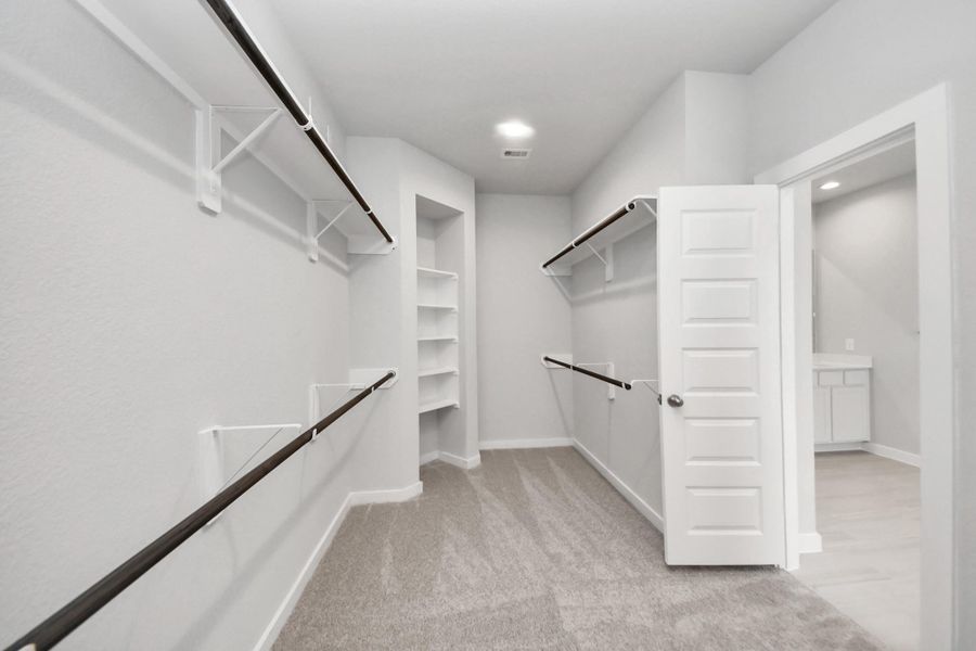 Walk-in closet that epitomizes luxury and practicality. This generously sized space features built-in shelving, offering abundant room for impeccable organization. High ceilings and recessed lighting create a bright and welcoming ambiance. Sample photo of completed home with similar floor plan. Actual colors and selections may vary. Walk-in closet that epitomizes luxury and practicality. This generously sized space features built-in shelving, offering abundant room for impeccable organization. High ceilings and recessed lighting create a bright and welcoming ambiance. Sample photo of completed home with similar floor plan. Actual colors and selections may vary.