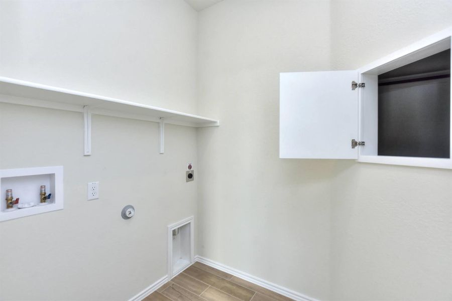 Laundry room featuring wood finish floors, gas dryer hookup, washer hookup, laundry area, and hookup for an electric dryer