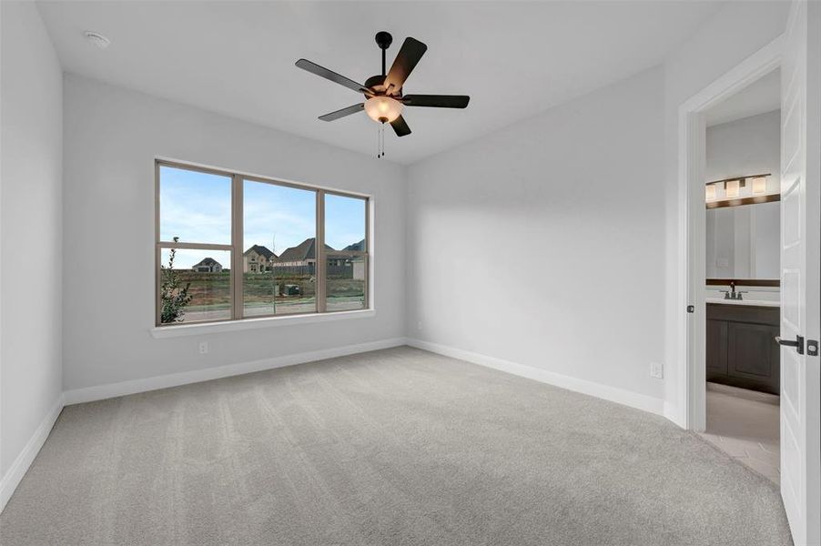 Unfurnished bedroom with light carpet, ceiling fan, and connected bathroom Unfurnished bedroom with light carpet, ceiling fan, and connected bathroom