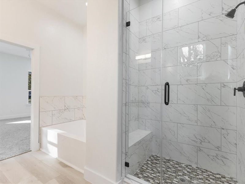Bathroom featuring a garden tub and a marble finish shower