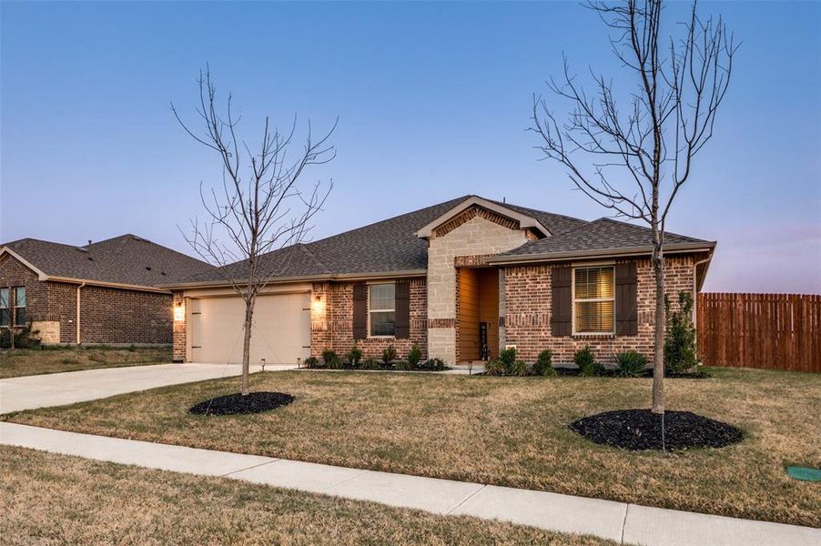 Ranch-style home featuring brick siding, concrete driveway, an attached garage, and a shingled roof