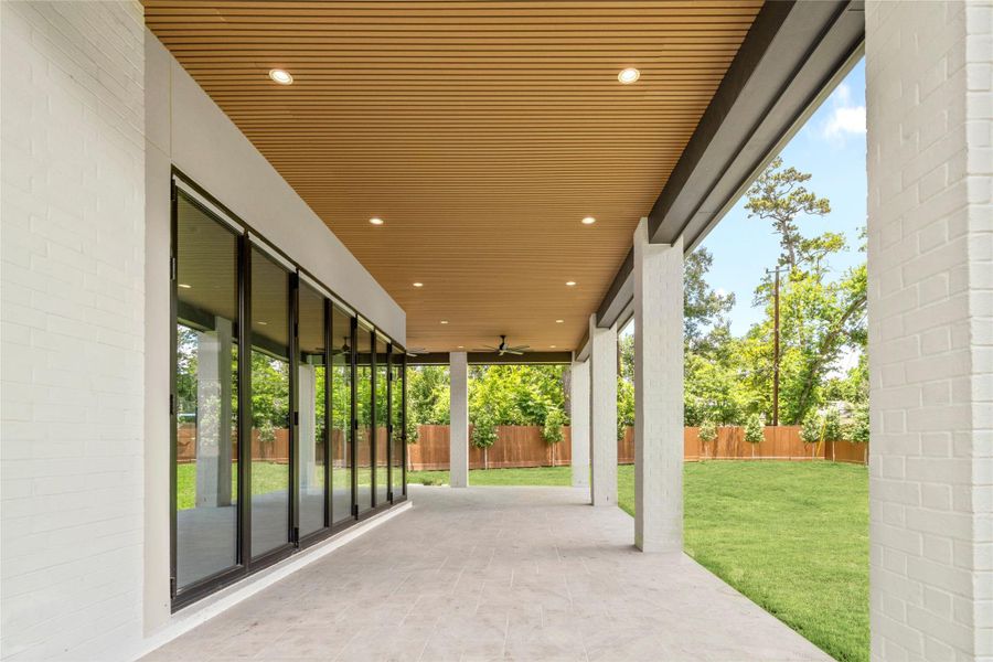 Large covered back patio with beautiful wood ceiling feature. Full accordion doors open up to family room.