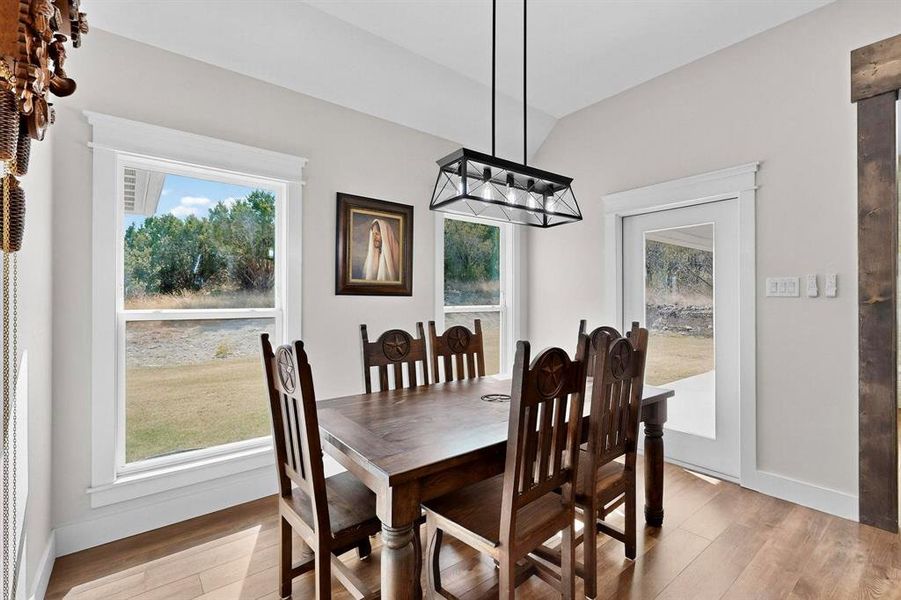 Dining room featuring light wood-type flooring and lofted ceiling
