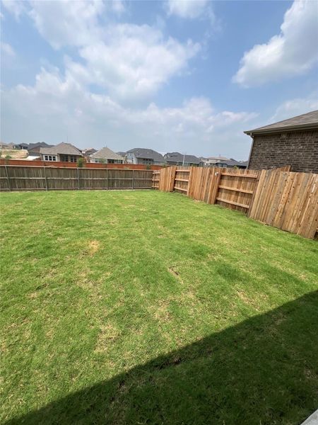 A spacious, completely fenced back yard awaits outdoor activities and relaxation.