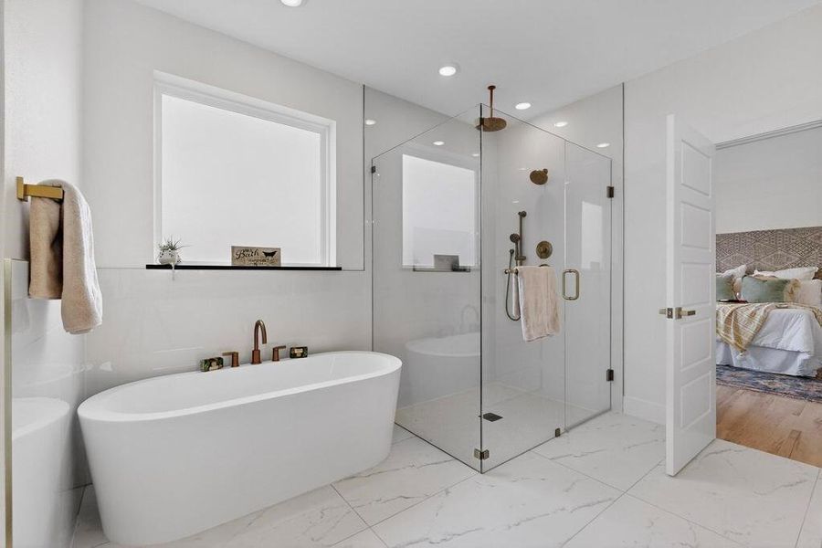 Bathroom with a soaking tub, a shower stall, connected bathroom, marble finish floors, and recessed lighting