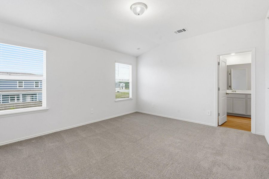 Carpeted room with white walls, two windows featuring horizontal blinds, and a flush mount ceiling light