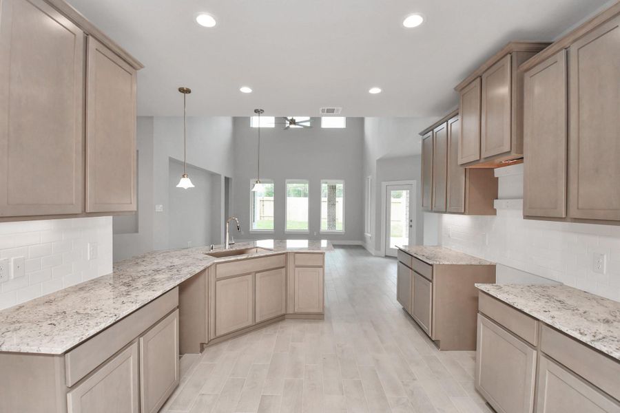 The kitchen is a culinary haven, featuring granite countertops, a tile backsplash, stainless steel appliances, 42” upper cabinets, and undercabinet lighting. Sample photo of completed home with similar floor plan. Actual colors and selections may vary.Sample photo of completed home with similar floor plan. Actual colors and selections may vary. The kitchen is a culinary haven, featuring granite countertops, a tile backsplash, stainless steel appliances, 42” upper cabinets, and undercabinet lighting. Sample photo of completed home with similar floor plan. Actual colors and selections may vary.Sample photo of completed home with similar floor plan. Actual colors and selections may vary.