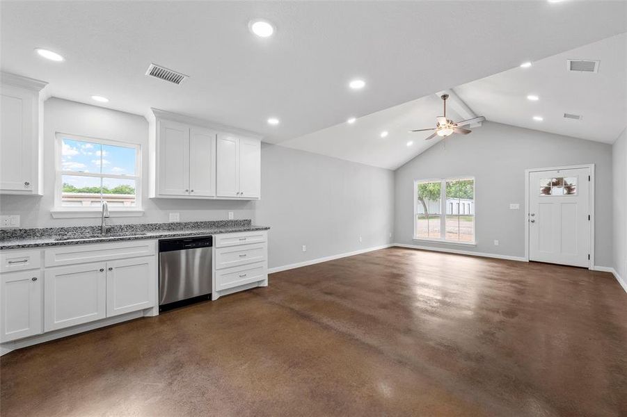 Kitchen featuring visible vents, stainless steel dishwasher, finished concrete flooring, and plenty of natural light