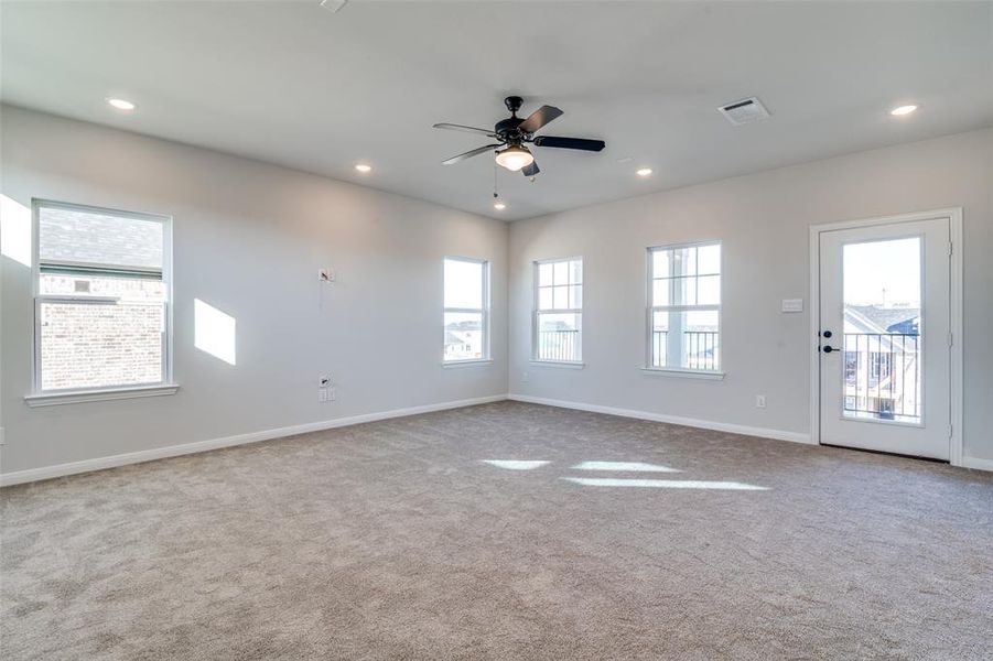 Empty room featuring ceiling fan and light carpet