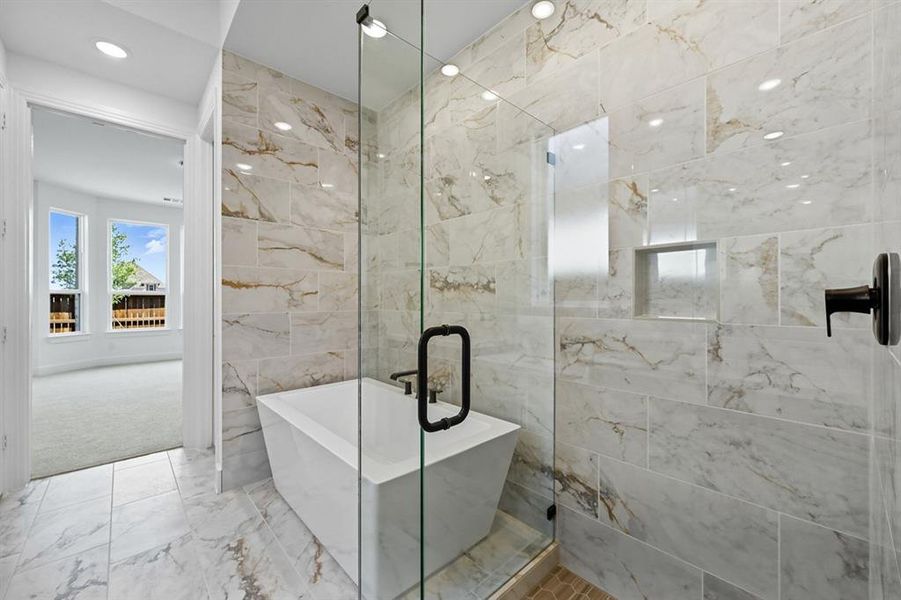Full bathroom featuring marble look tile flooring, a freestanding tub, tile walls, recessed lighting, and a shower stall Full bathroom featuring marble look tile flooring, a freestanding tub, tile walls, recessed lighting, and a shower stall