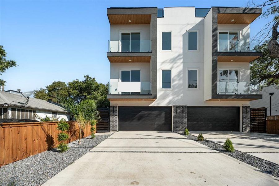 Modern home with stucco siding, a balcony, and driveway Modern home with stucco siding, a balcony, and driveway