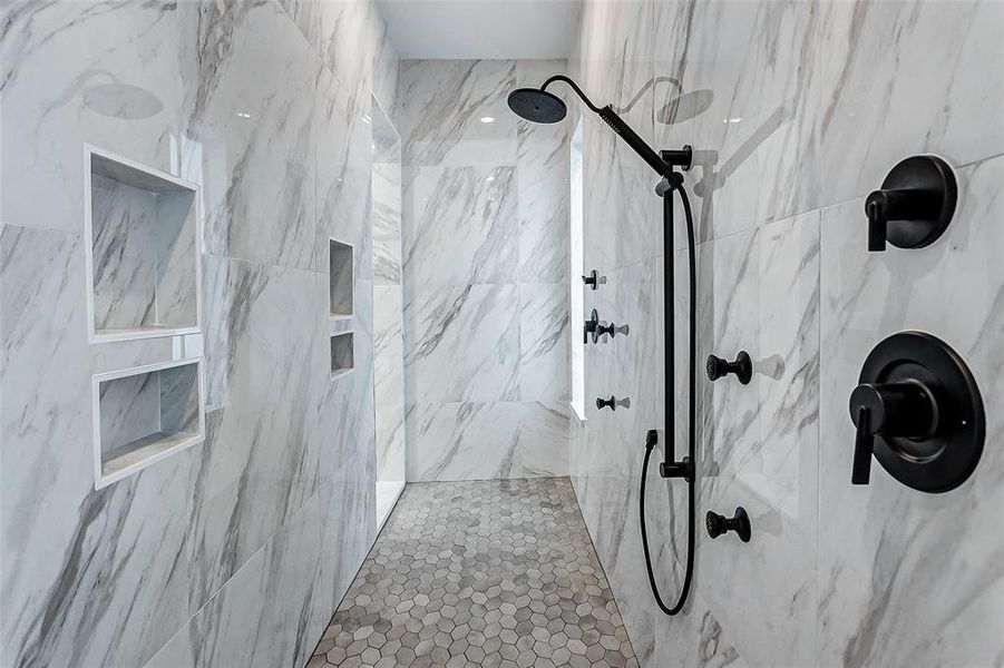 The massive walk-in shower features dual shower heads, a body shower head, and several built-in inserts. The marble-look tile surround, upgraded tile flooring, window and disk lights make this a true spa experience!