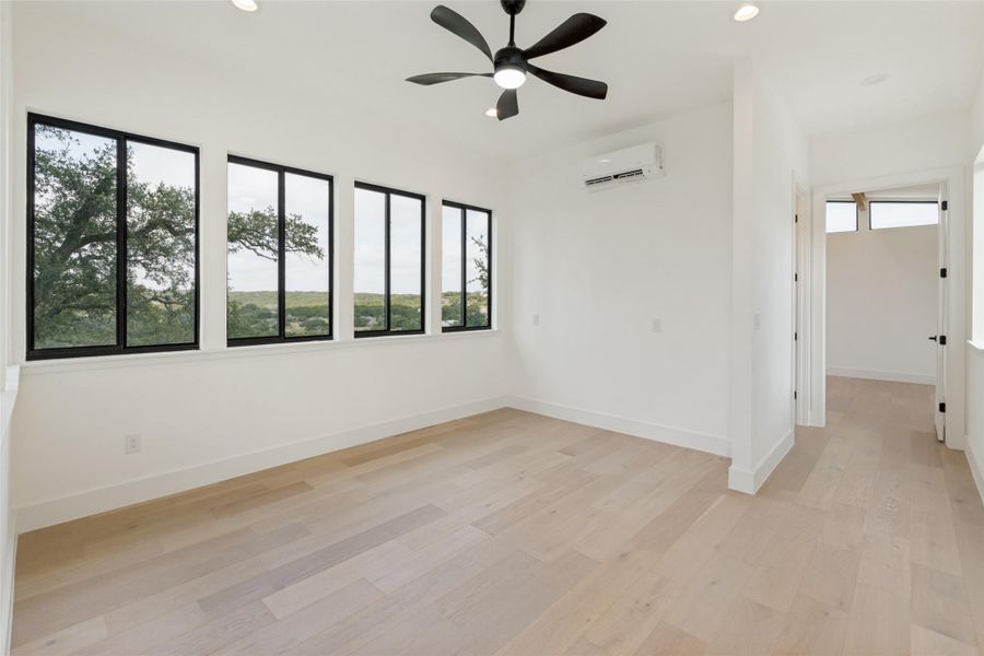 An airy room offers abundant natural light and serene tree-filled views.