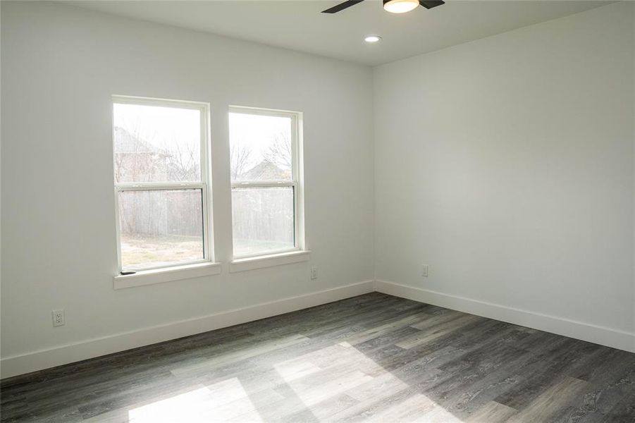 Unfurnished room featuring hardwood / wood-style flooring, a wealth of natural light, and ceiling fan