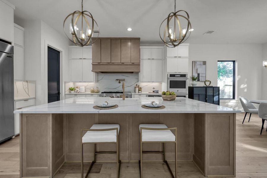Modern kitchen with oversized island, pendant lighting, and wood cabinetry. Modern kitchen with oversized island, pendant lighting, and wood cabinetry.