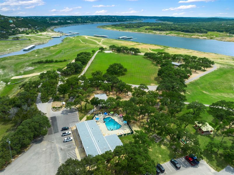 Aerial view of property and surrounding area featuring a large body of water and a pool area