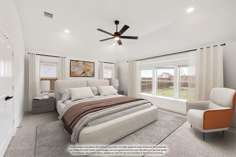 Spacious master bedroom with ceiling fan, large windows, carpet flooring, and neutral decor