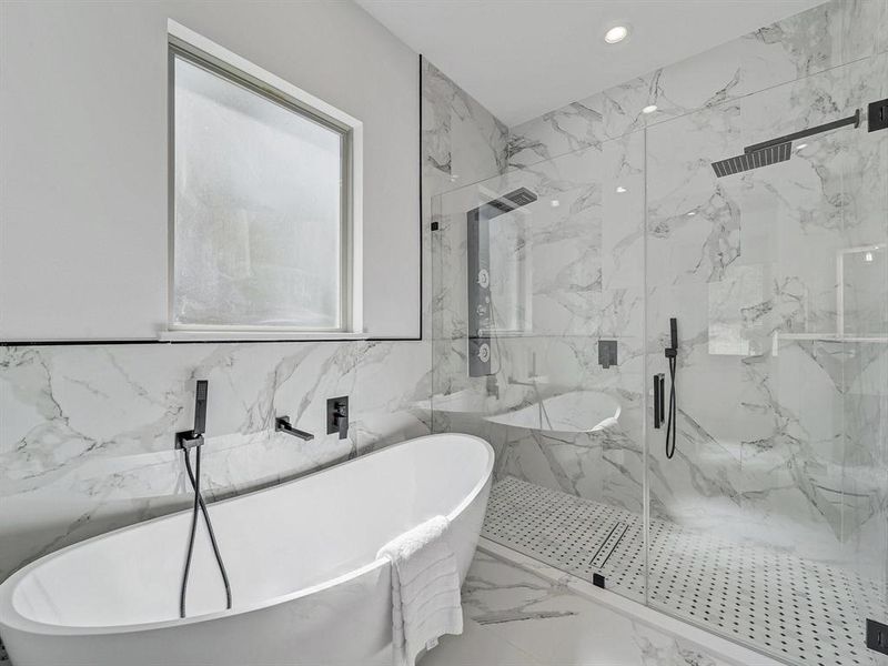 Bathroom featuring a marble finish shower, a freestanding bath, marble finish floors, recessed lighting, and tile walls