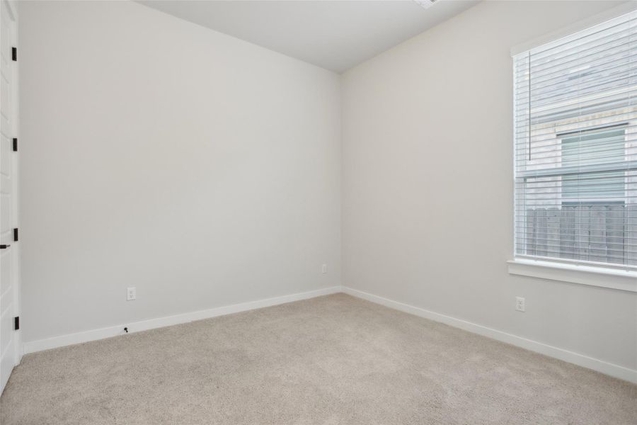 Spare room featuring light carpet and baseboards