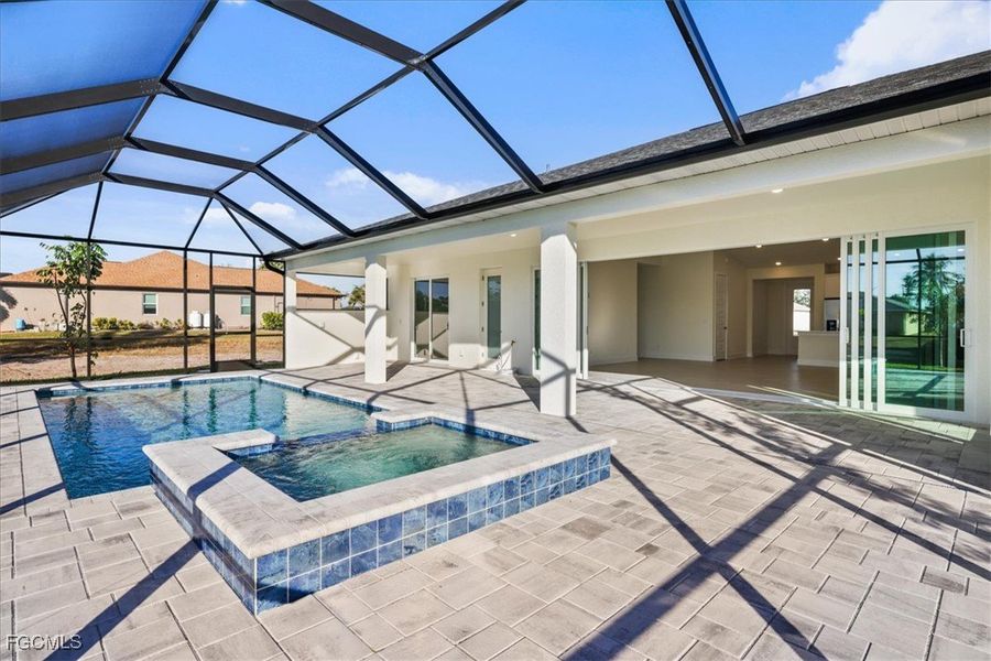 View of swimming pool featuring a sunroom, a pool with connected hot tub, a patio area, and a lanai