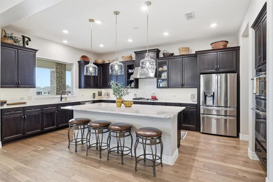The Gourmet Cook’s Kitchen features GE Café Appliances, Cristal Gold Quartzite Island and Quartz Countertops, Upgraded Neutral Cabinetry, and a Large Picture Window capturing Golf Course and Territorial Views.