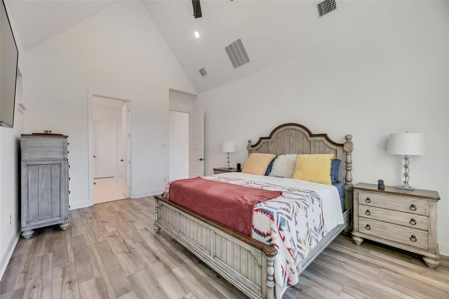 Bedroom featuring high vaulted ceiling, a ceiling fan, and light wood-type flooring