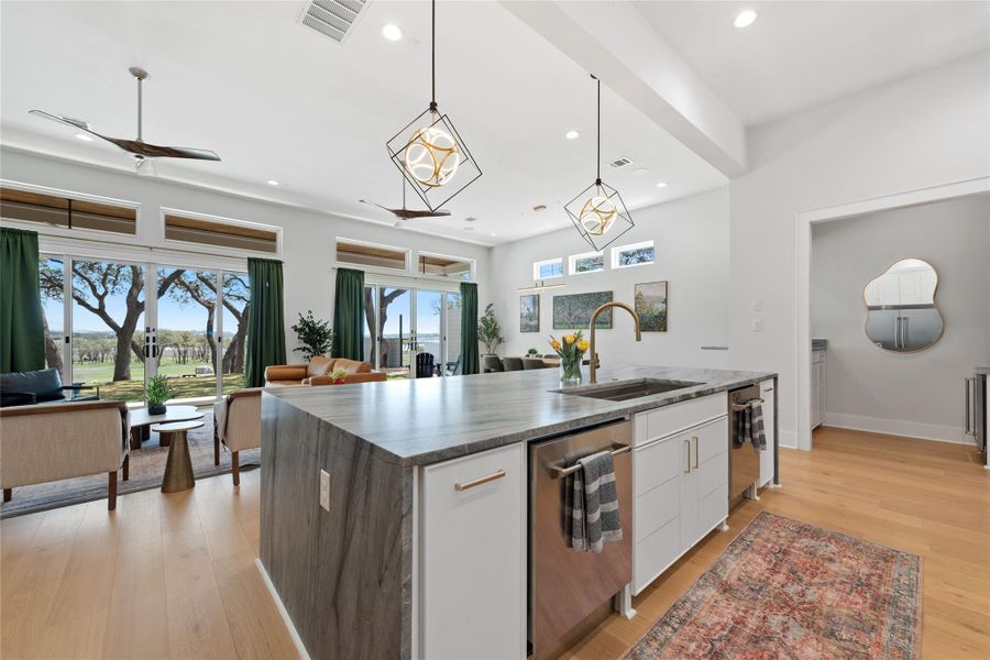 The heart of the home seamlessly connects the kitchen, dining, and living areas beneath soaring ceilings, while walls of glass frame picturesque views and flood the interior with natural light. The heart of the home seamlessly connects the kitchen, dining, and living areas beneath soaring ceilings, while walls of glass frame picturesque views and flood the interior with natural light.