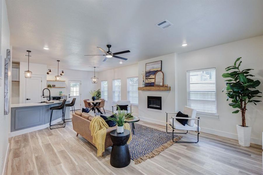 Living room featuring light wood-type flooring, plenty of natural light, and sink