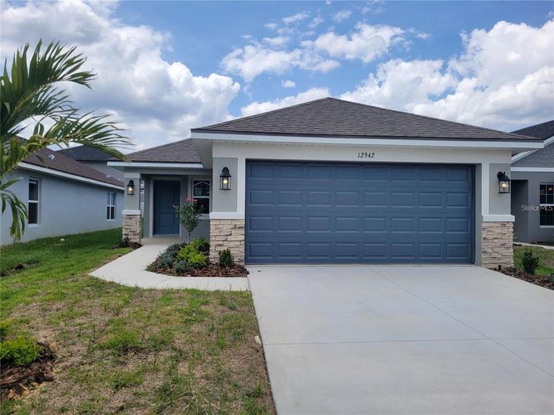 Front exterior of a new home in Highland Hills, Hudson, FL, highlighting curb appeal (Image 13).