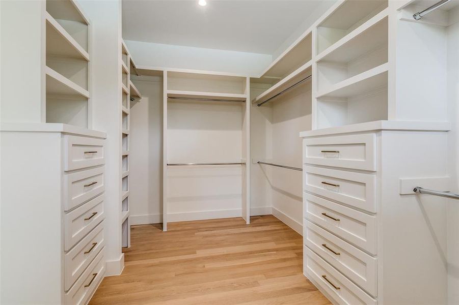 Spacious closet with light wood-style floors Spacious closet with light wood-style floors