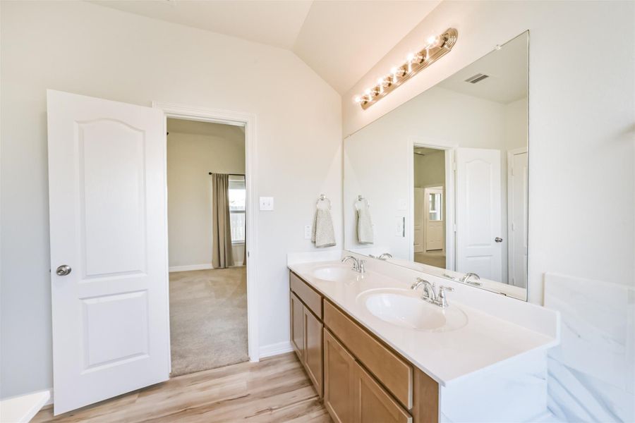 This alternate view of the vanity showcases the generous amount of storage space, along with a large mirror and updated lighting that keeps the ensuite feeling bright and functional. This alternate view of the vanity showcases the generous amount of storage space, along with a large mirror and updated lighting that keeps the ensuite feeling bright and functional.