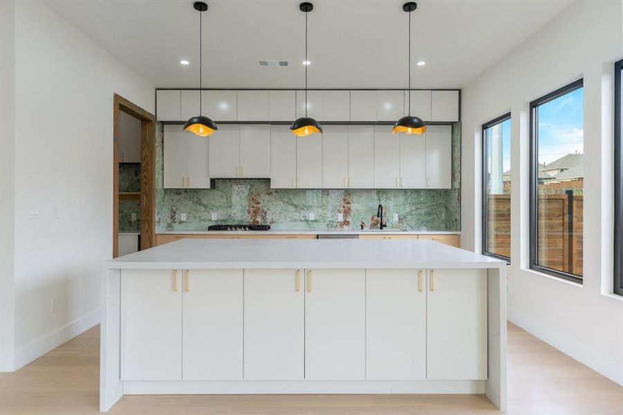 Kitchen with white cabinets, hanging light fixtures, backsplash, modern cabinets, and recessed lighting