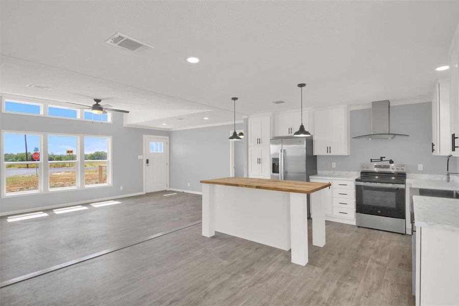 Smooth wood floors flow effortlessly from the modern kitchen into the airy living room.