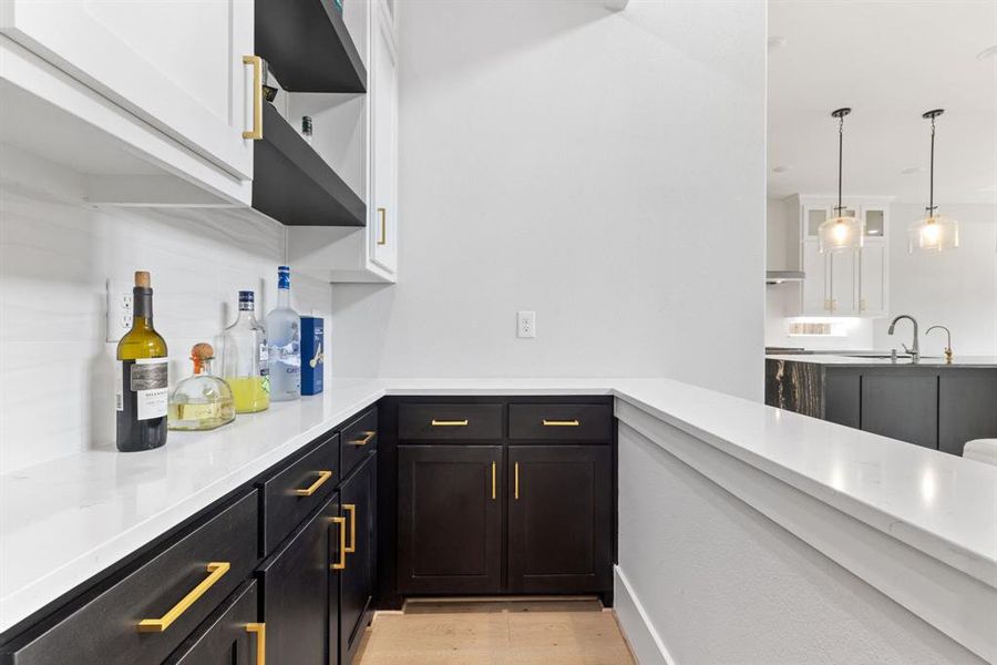 Kitchen featuring light countertops, white cabinetry, hanging light fixtures, and light wood finished floors