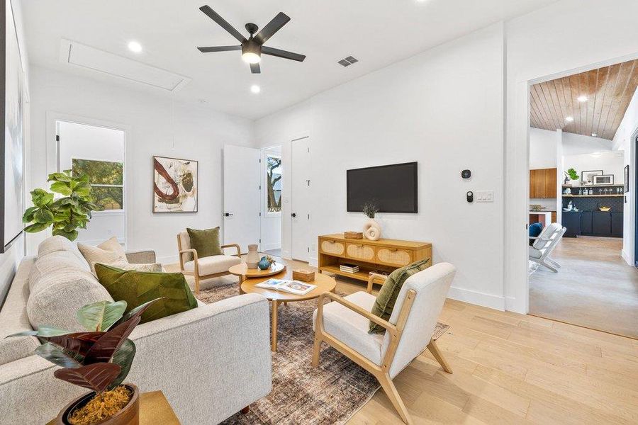 Living room featuring light wood finished floors, attic access, recessed lighting, vaulted ceiling, and a ceiling fan