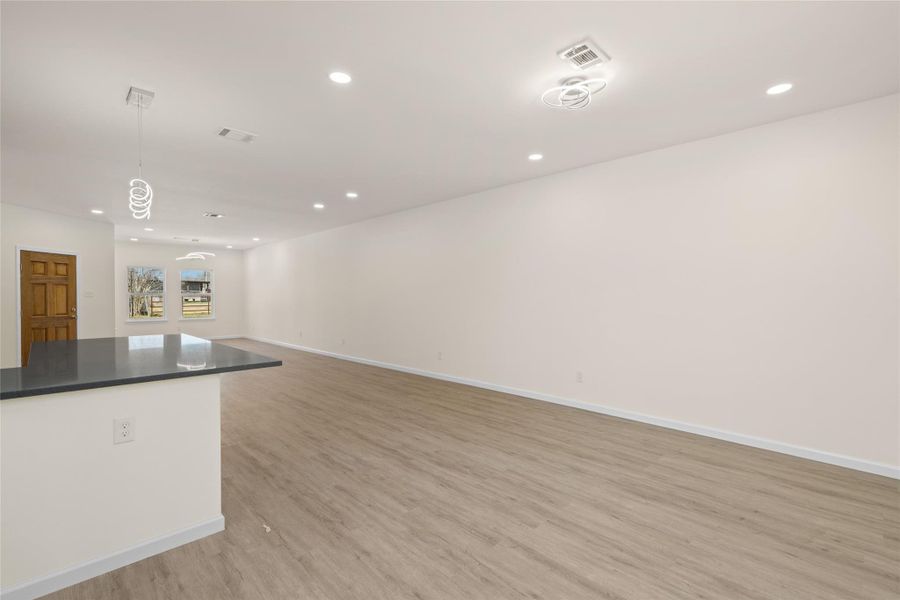 Bright, open living area with wide-plank flooring and recessed lighting throughout.