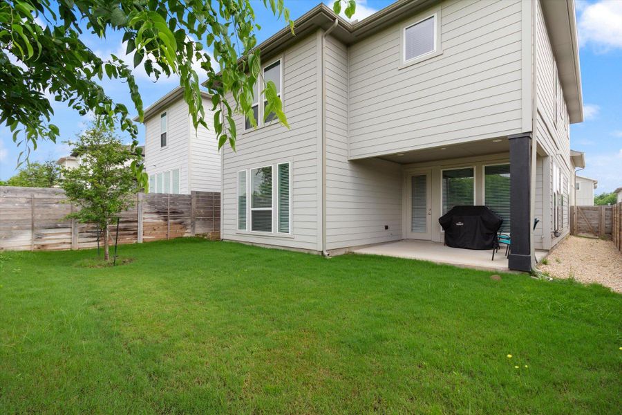 Rear view of property with a fenced backyard and a patio area