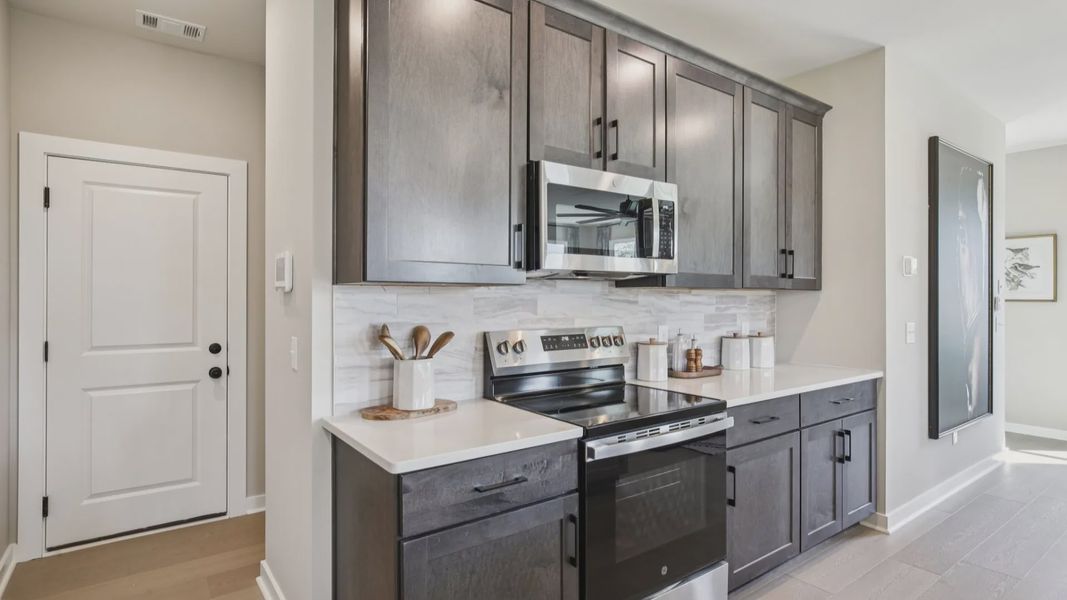 Kitchen with quartz countertops and dark cabinetry