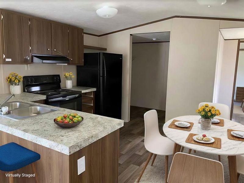 Kitchen with sink, dark hardwood / wood-style flooring, range hood, lofted ceiling, and black Electrolux appliances