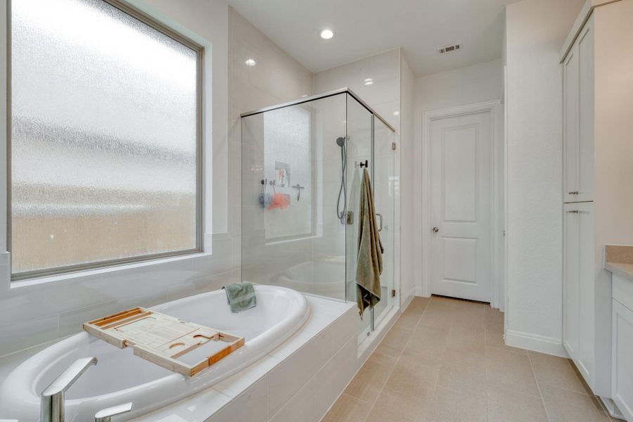 A soaking tub and separate glass-enclosed shower create two different ways to unwind.