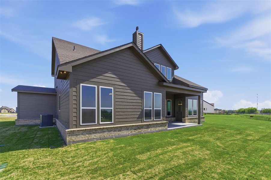 Rear view of house featuring a patio, a yard, and a chimney Rear view of house featuring a patio, a yard, and a chimney