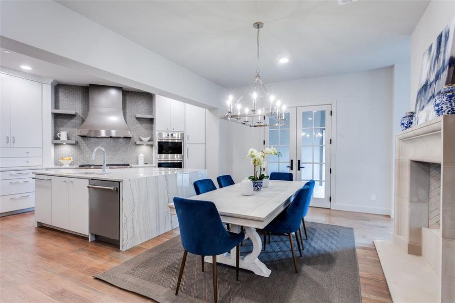 Dining room with an inviting chandelier, french doors, and light wood-type flooring