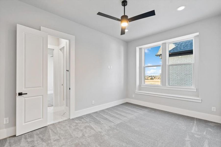 Carpeted spare room with ceiling fan