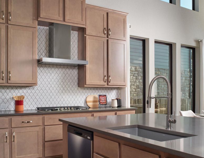 Kitchen featuring dark countertops, wall chimney range hood, stainless steel appliances, and backsplash