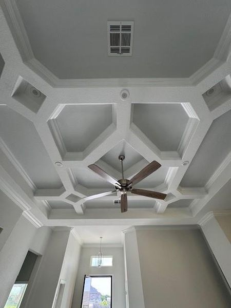 Detailed view of ornamental molding, coffered ceiling, beam ceiling, and ceiling fan