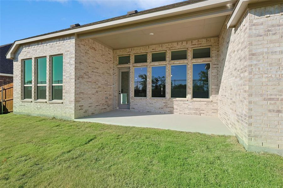 Rear view of house featuring a patio area and a yard