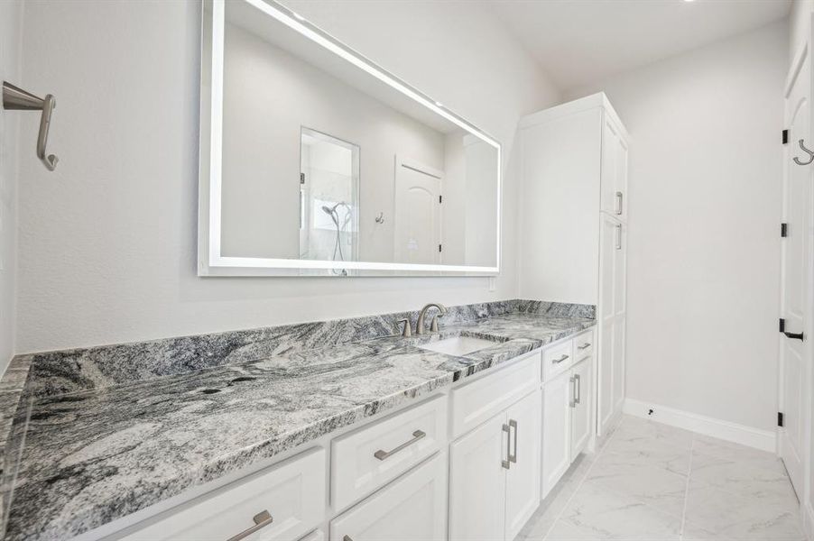 Oversized vanity with large linen storage closet, shower enclave, and toilet room.